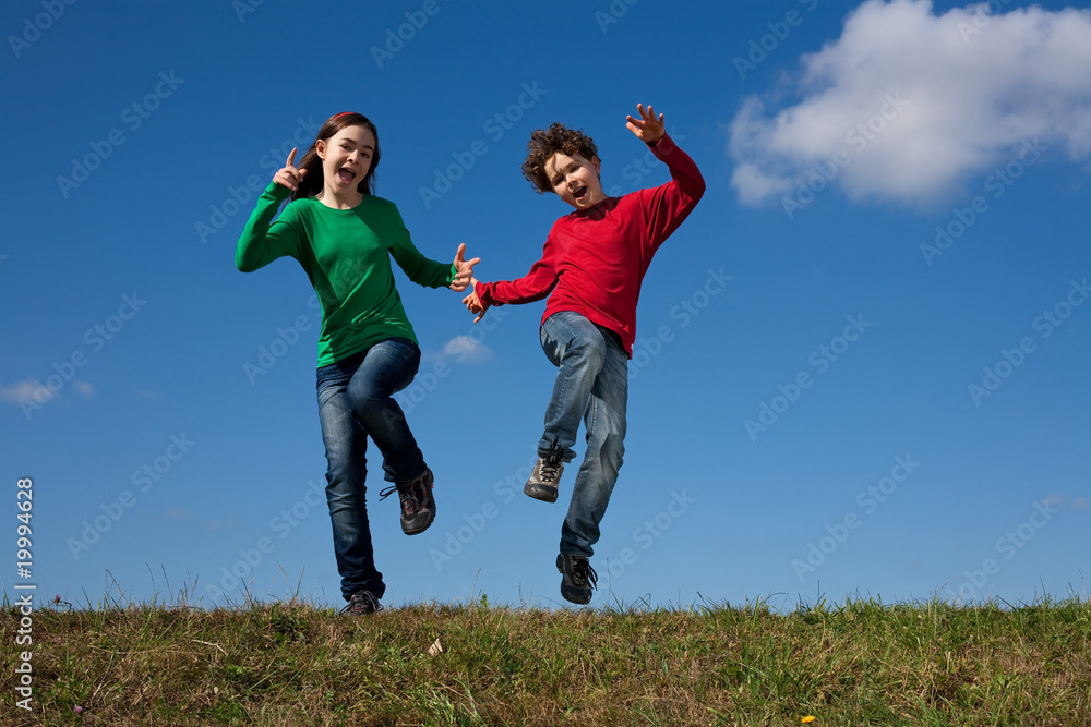 Kids jumping, running against blue sky Kids jumping, running against blue sky