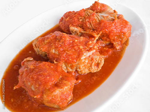 Meat roulade with tomato sauce on plate.