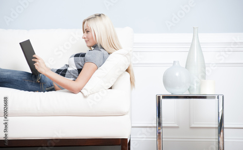 Woman Reclining on Couch With a Book