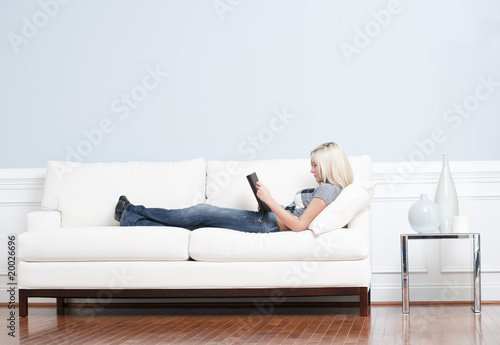 Woman Reclining on Couch With Book