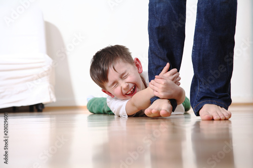 Kind weint und hält sich am Bein der Mutter fest schreit