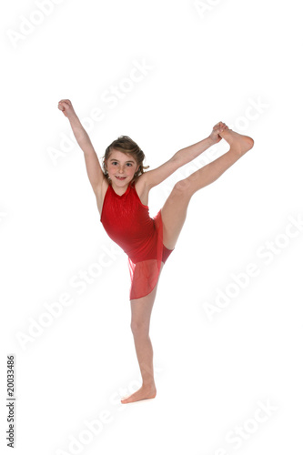 young girl doing a split and wearing red leotard