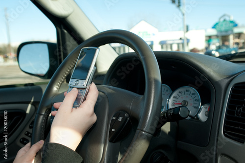 Hand of a teen texting while driving