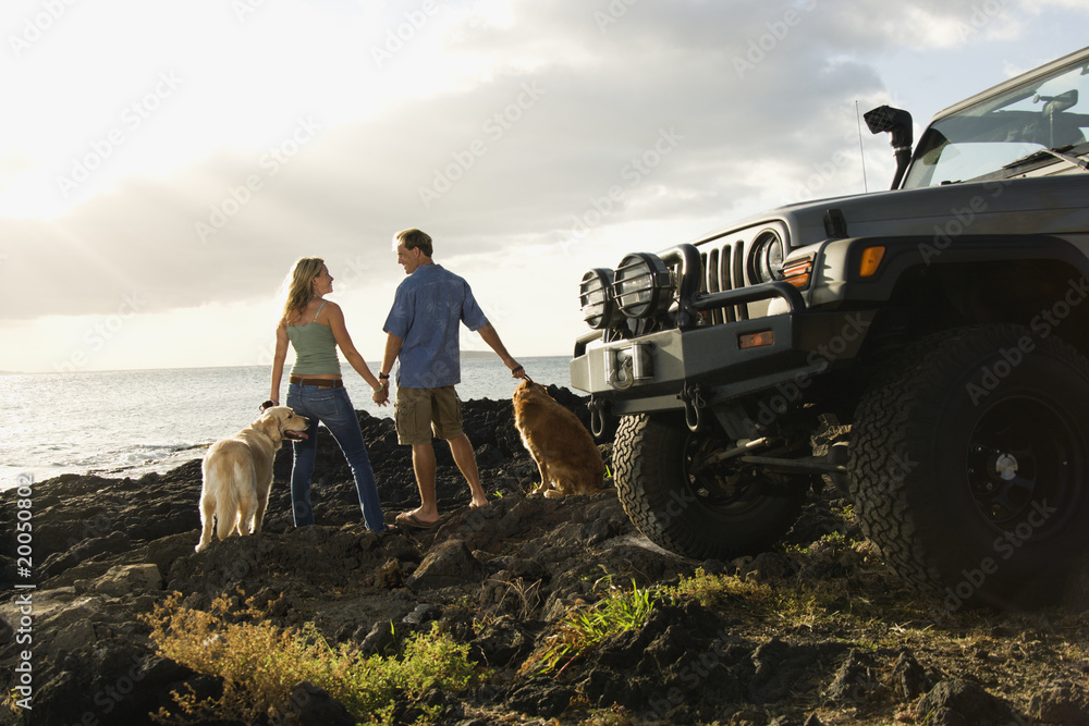 Obraz premium Couple and Dogs at the Beach
