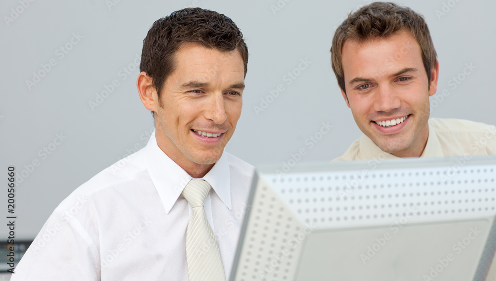 Two businessmen working together at a computer Two businessmen working together at a computer