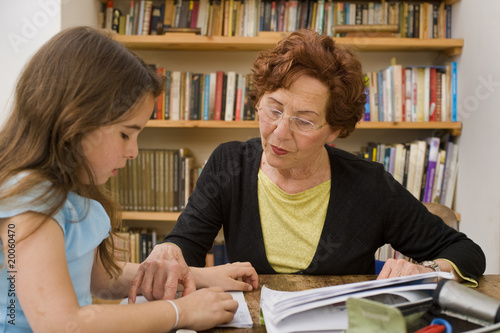 senior halping child doing homework photo