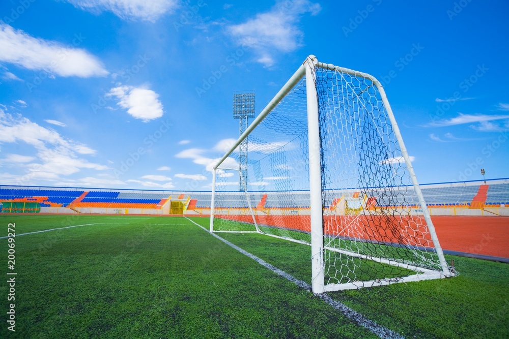 Fototapeta premium STADIUM - Football field with goal and tablo on blue sky