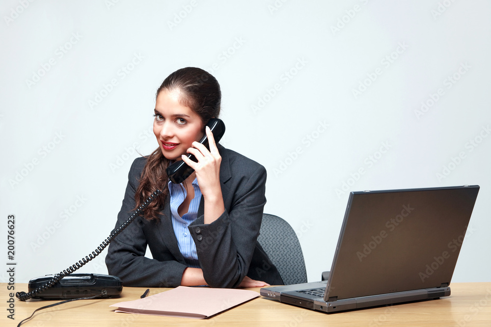 Businesswoman sat at a desk on the telephone