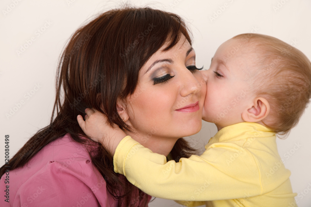 Little daughter kissing her mother. Close up