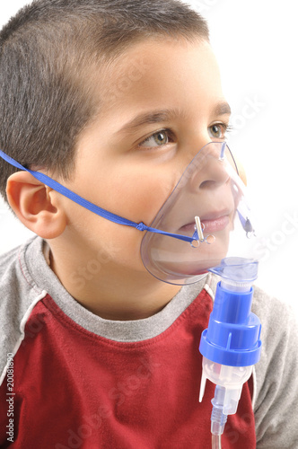 Close up image of a little boy with asthma using oxygen mask.