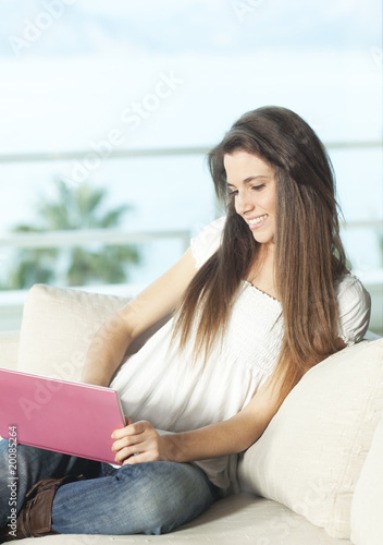 Happy young woman with pink netbook Free Download Happy young woman with pink netbook - GFXLoad