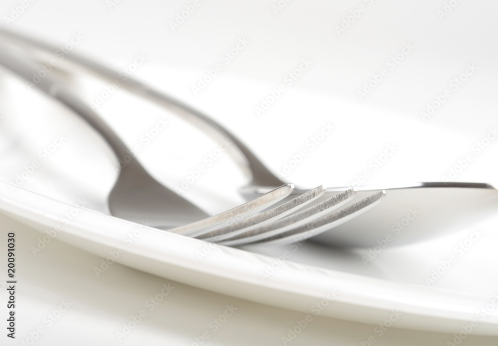 Photo of fork and spoon on plate. Photo of fork and spoon on plate.