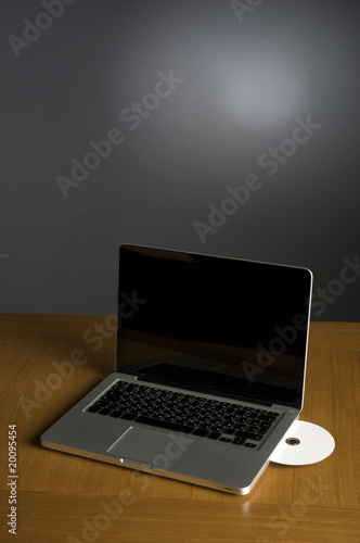 Laptop and CD on background