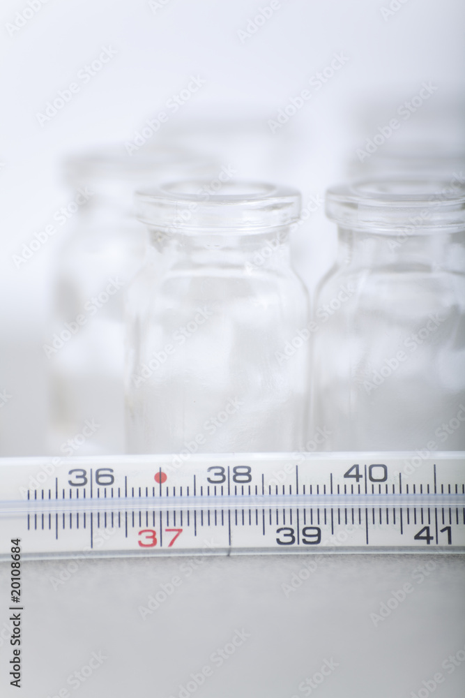 Thermometer and bottles of pills Thermometer and bottles of pills