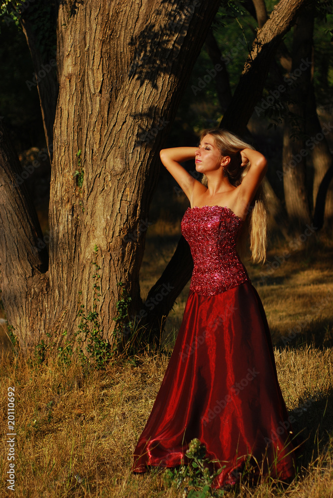 Portrait of the beautiful blonde with long hair in red dress Portrait of the beautiful blonde with long hair in red dress
