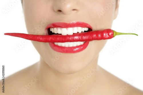 Beautiful woman teeth eating red pepper