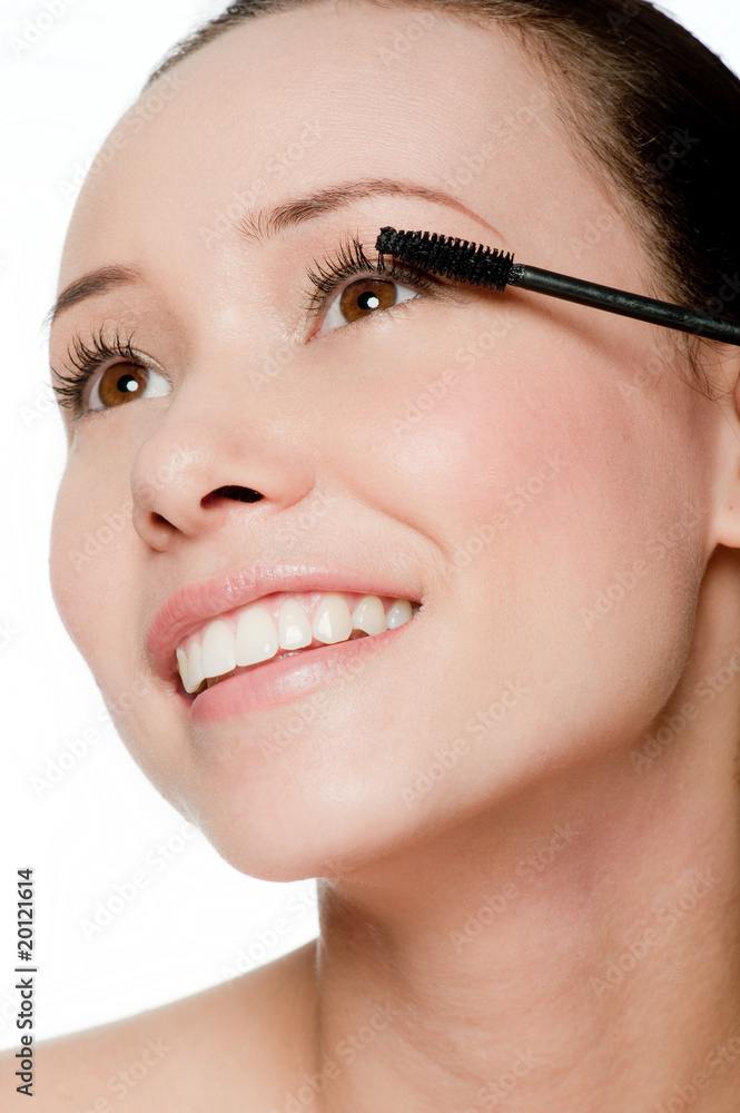 Young and attractive woman applying mascara
