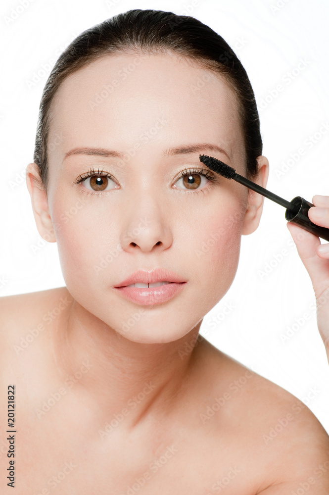 Young and attractive woman applying mascara Young and attractive woman applying mascara