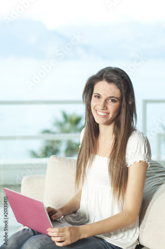 Free Download Happy young woman with pink netbook - GFXLoad