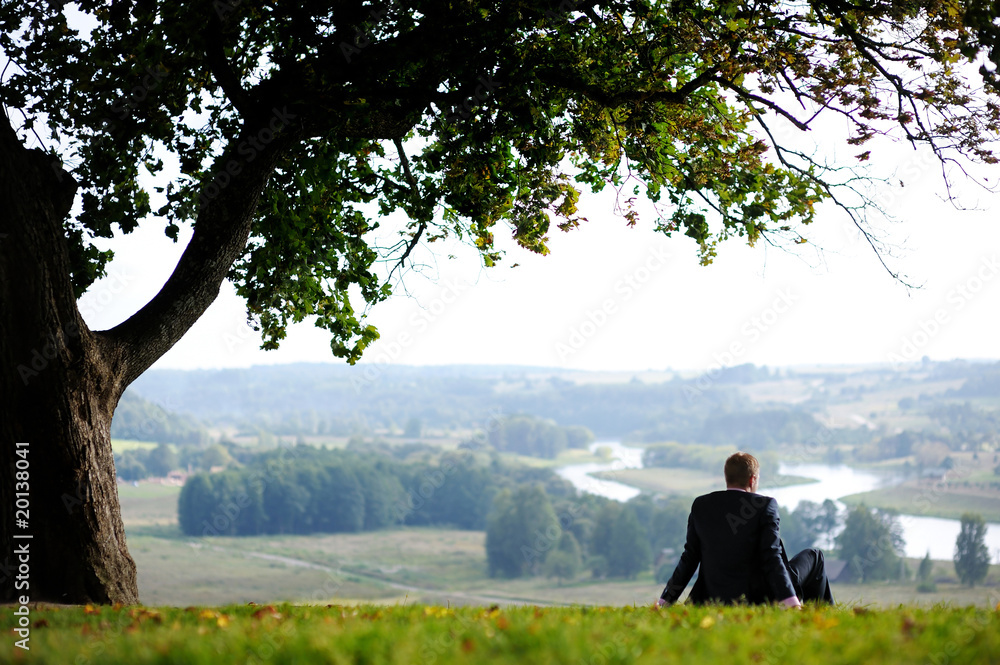 Business man resting under an oak Business man resting under an oak