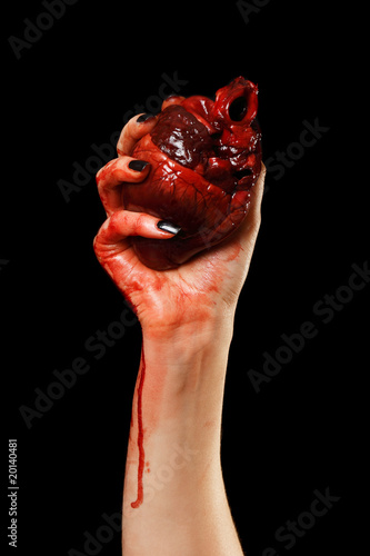 Human heart in hand isolated on black