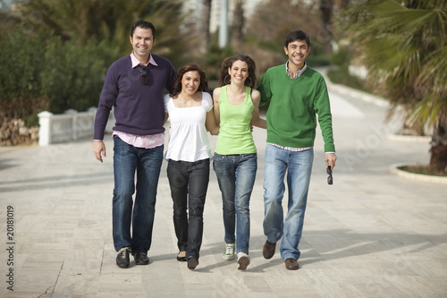 Four happy people walking