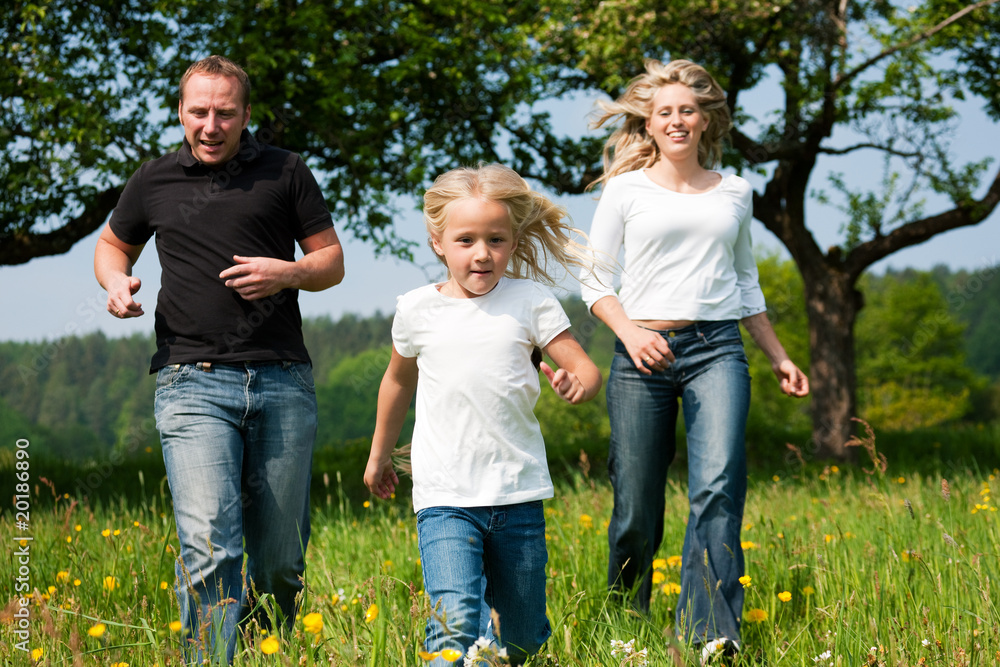 Family running on meadow in spring Family running on meadow in spring