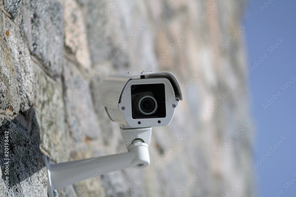 Surveillance camera mounted on a wall outside the building Surveillance camera mounted on a wall outside the building