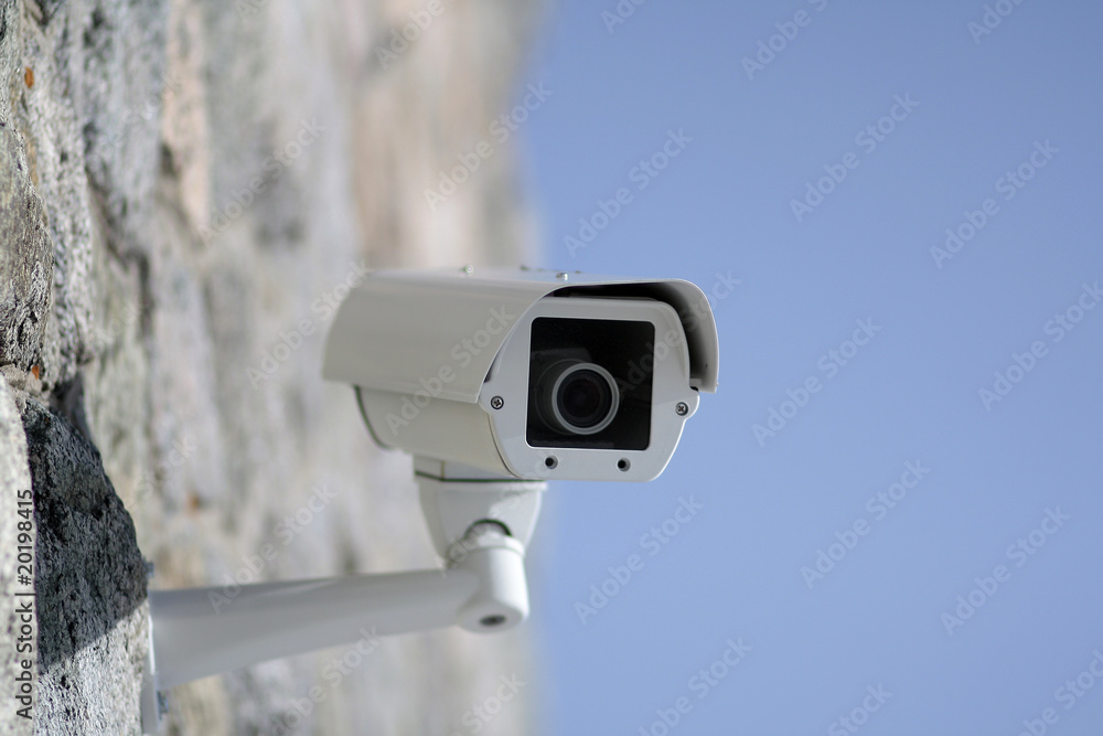 Surveillance camera mounted on a wall outside the building Surveillance camera mounted on a wall outside the building