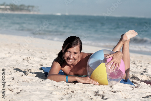 Woman lying on beach, smiling to the camera