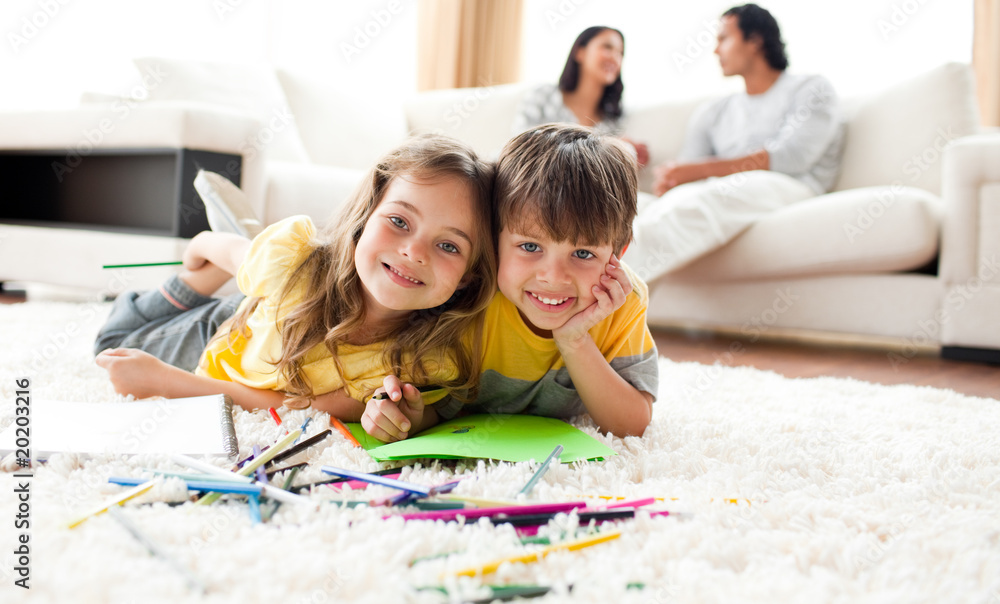 Adorable btother and sister drawing lying on the floor Adorable btother and sister drawing lying on the floor