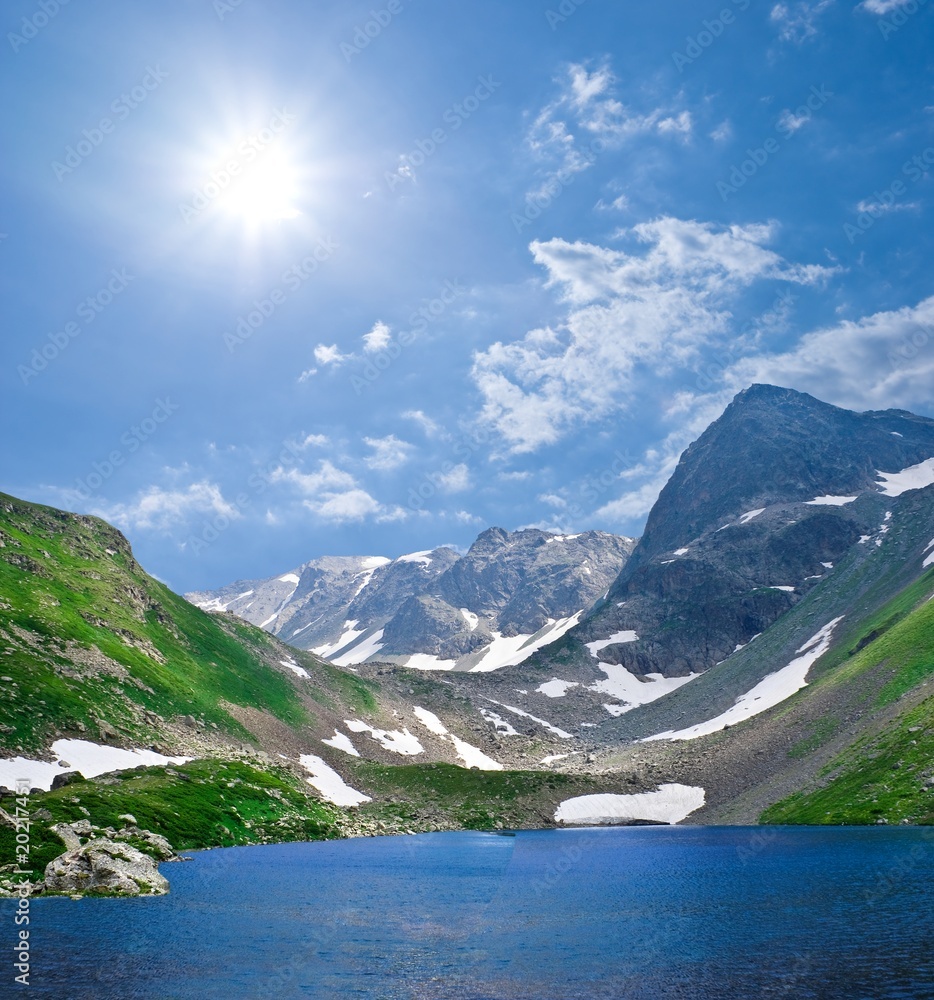 blue lake in a mountain valley by a spakle day