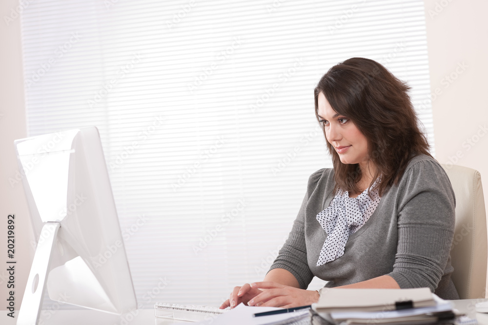 Young business woman working with computer at office Young business woman working with computer at office