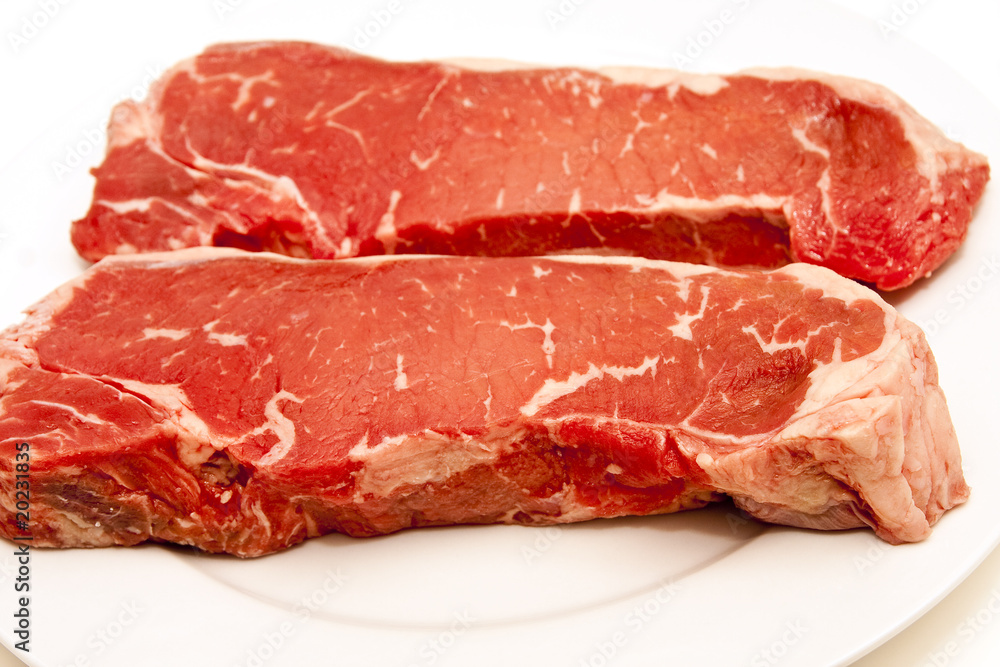 Two Large Strip Steaks on White Plate