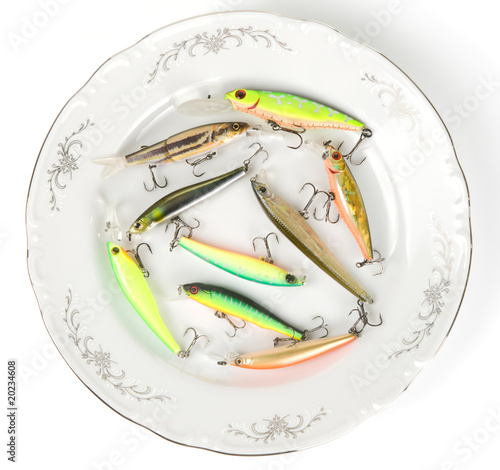 Porcelain plate with plastic fishing lures isolated on white photo