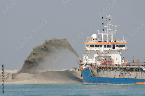 Dredge ship pipe pushing sand to create new land