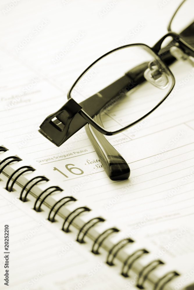 Opened blank notebook and spectacles Opened blank notebook and spectacles