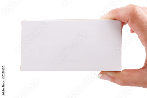 Caja de medicina en blanco sujeta con una mano femenina