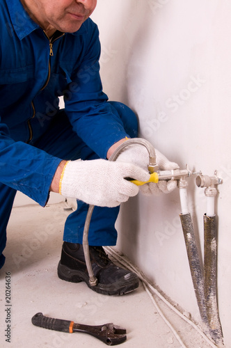 Plumber fixing water pipe