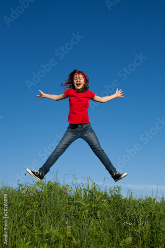 Girl jumping against blue sky