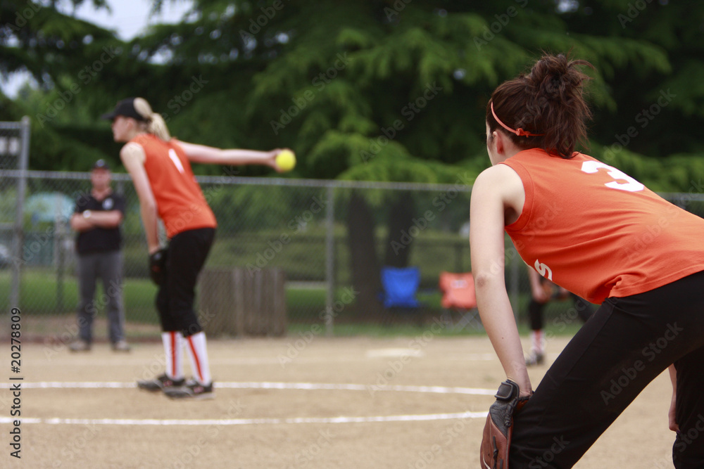 first basemen getting ready as the pitcher throws the ball