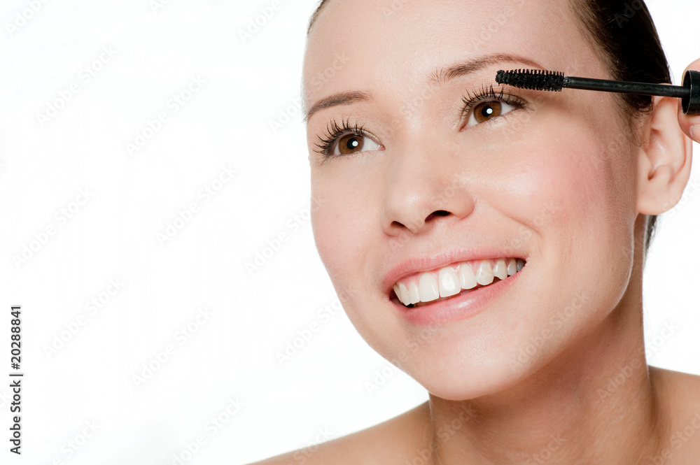Young and attractive woman applying mascara Young and attractive woman applying mascara