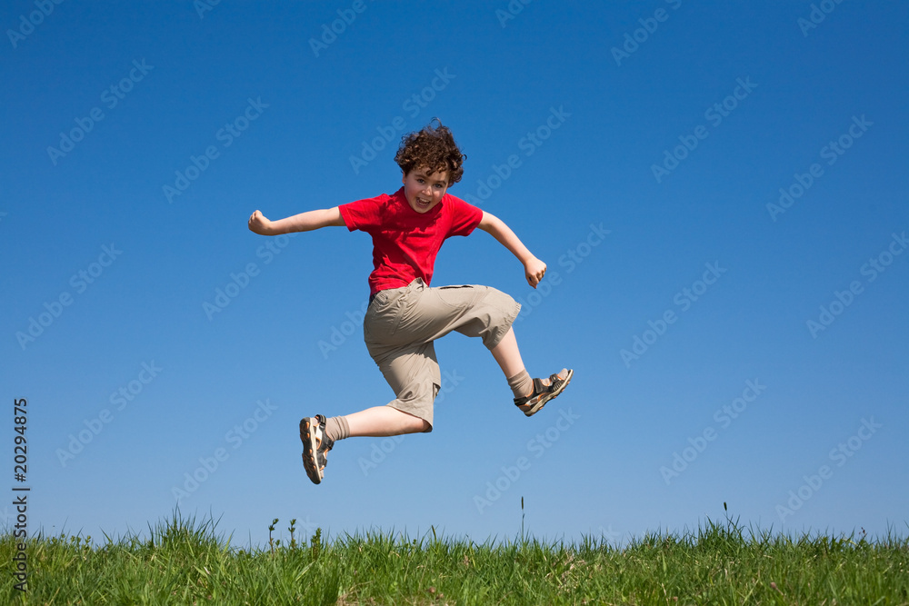 Boy jumping, running against blue sky Boy jumping, running against blue sky