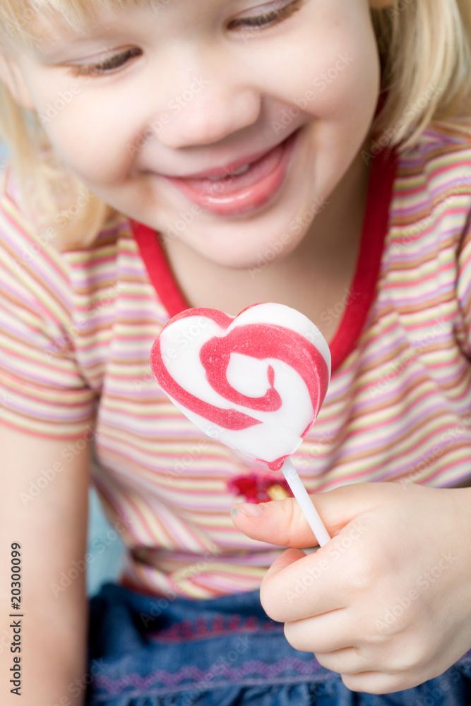 Little girl with a heart shape lollipop Little girl with a heart shape lollipop