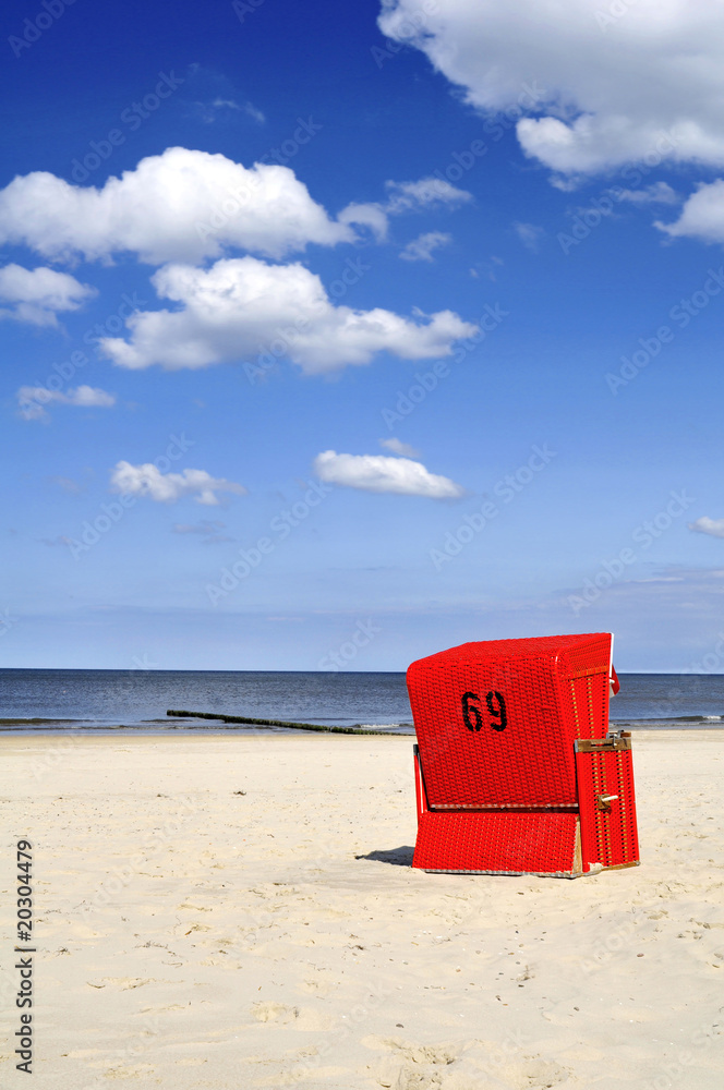 Naklejka premium Roter Strandkorb am Meer Hochformat