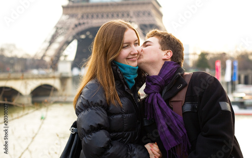 Happy loving couple near in Paris kissing near the Eiffel Tower
