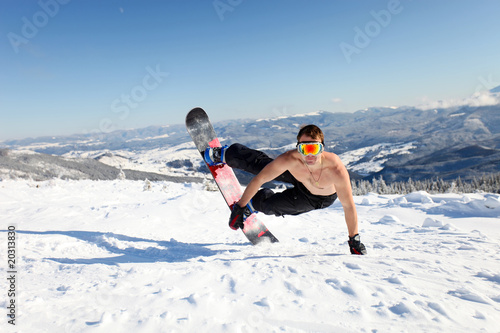 Snowboarder jumps up on the mountain slope