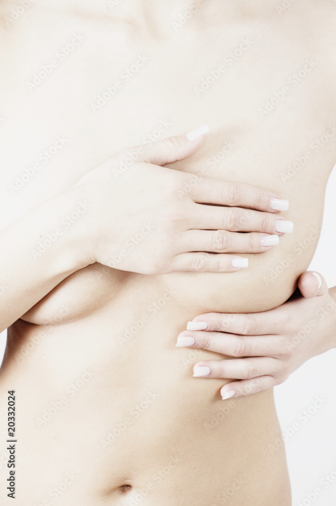 woman checking breats for signs of breast cancer woman checking breats for signs of breast cancer