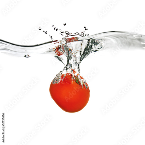  red tomato dropped into water isolated on white