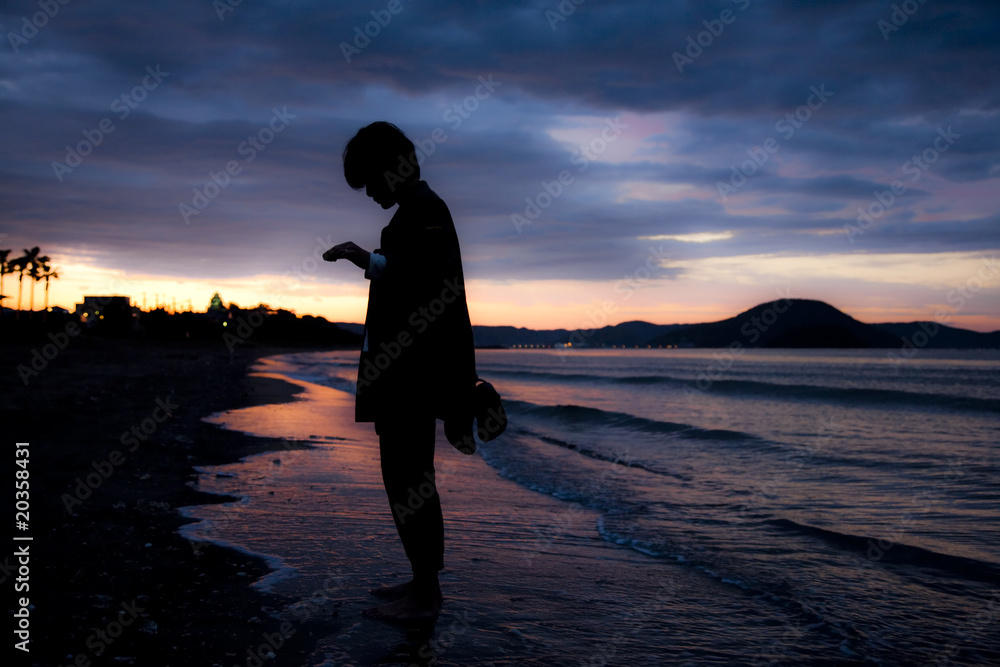 Silhouette of a woman at dramatic sunset at the beach